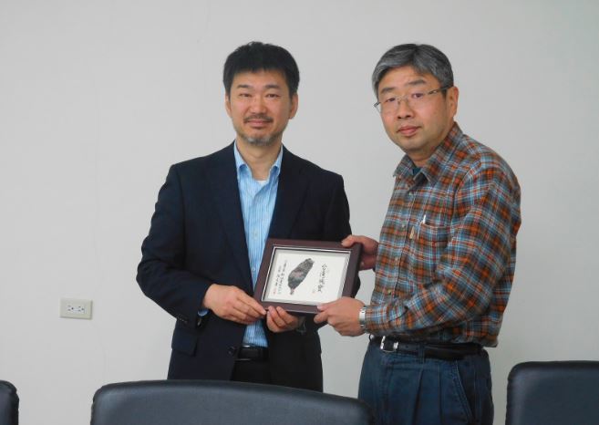 Professor of the TUS and Director Chang of the center exchanging souvenirs